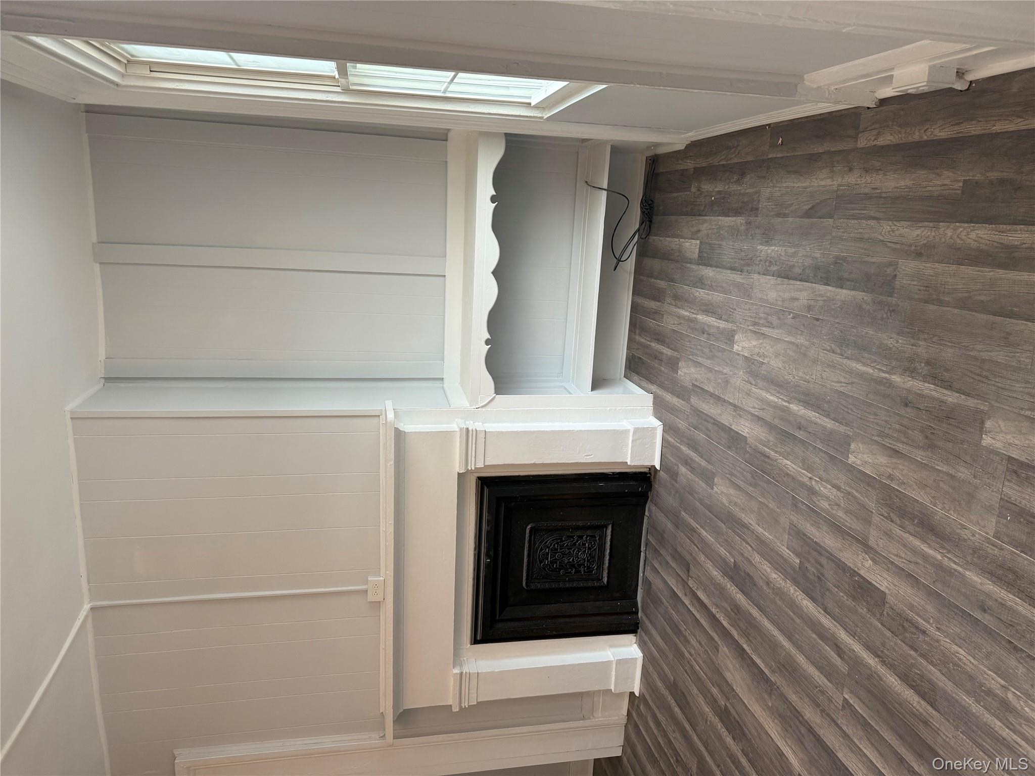 17 Conklin Street, Unit 1 Poughkeepsie, NY 12601 - Photo 15 of 17 Unfurnished living room featuring a decorative wall, dark wood-style floors, and a fireplace