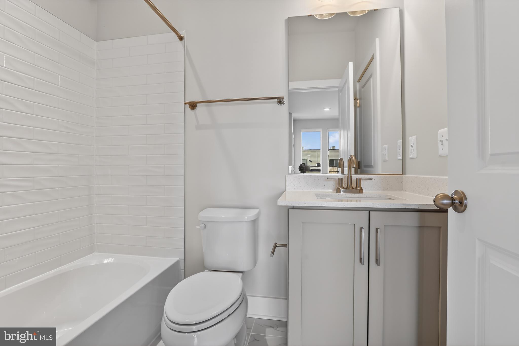 2716 Light Street Baltimore, MD 21230 - Photo 17 of 20 a bathroom with a toilet a sink a mirror a bathtub and vanity