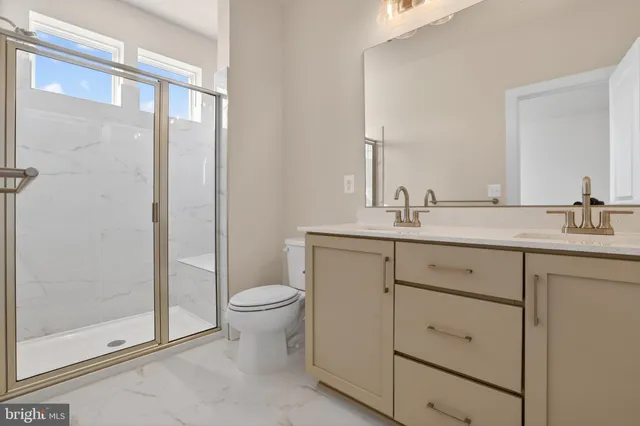 a bathroom with a granite countertop sink toilet and shower