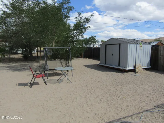a view of backyard with wooden fence