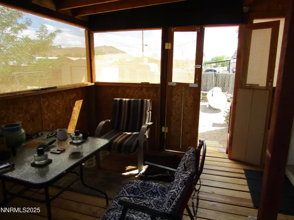 a view of a balcony with chairs and wooden floor