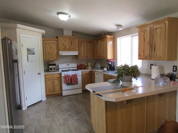 a kitchen with kitchen island granite countertop a sink stove and refrigerator