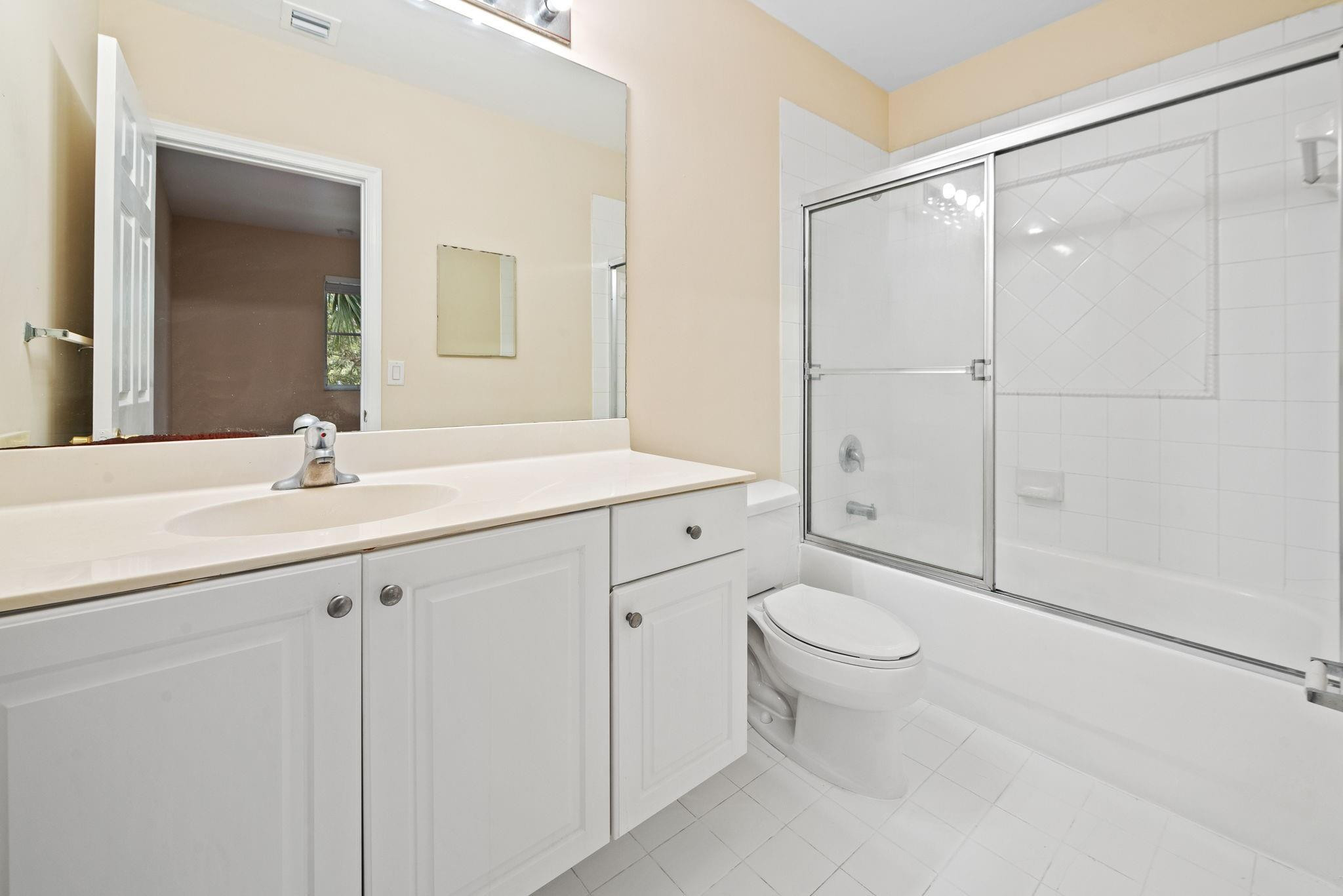 8299 Southwest 27th Street, Unit 101 Miramar, FL 33025 - Photo 15 of 30 a bathroom with a sink a toilet and a mirror