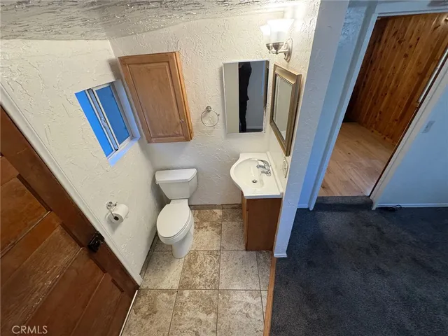 a bathroom with a granite countertop sink mirror vanity and toilet
