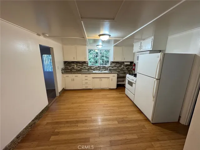 a kitchen with stainless steel appliances granite countertop a refrigerator and a stove