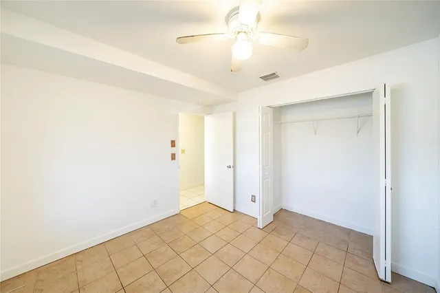 a view of a room with a ceiling fan and wooden floor