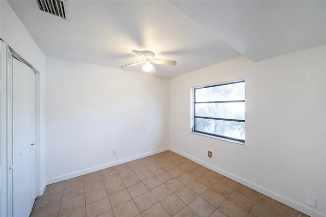 an empty room with windows and fan