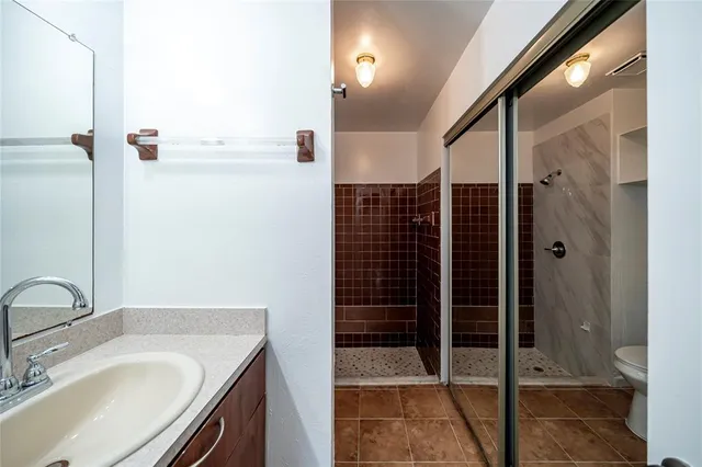 a bathroom with a shower sink and mirror