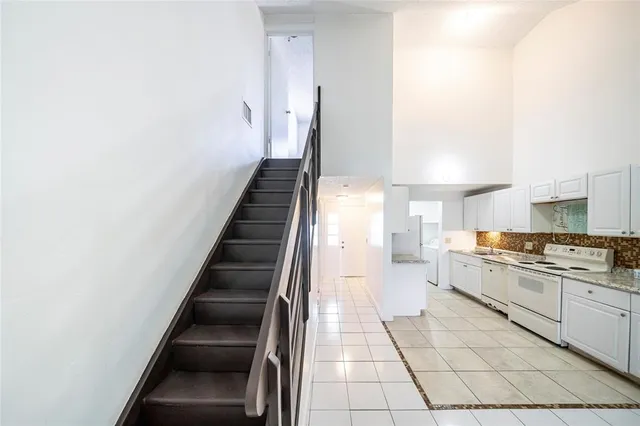 a large white kitchen with sink and stainless steel appliances