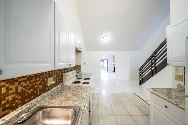 a kitchen with granite countertop a sink and a stove