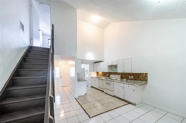 a kitchen with stainless steel appliances granite countertop a refrigerator and a stove