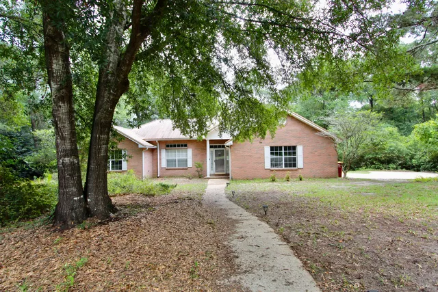 a front view of a house with a yard and trees