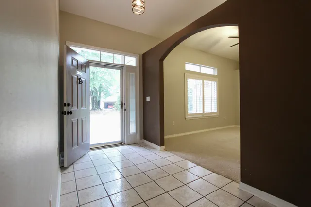 a view of a hallway with wooden floor and a door
