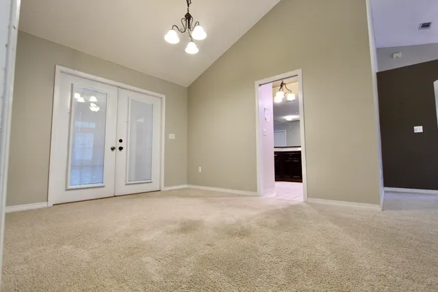 an empty room with windows and cabinet