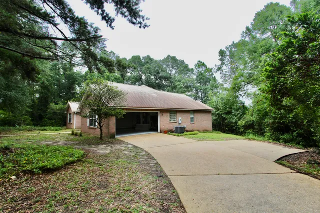 a front view of a house with a yard and trees