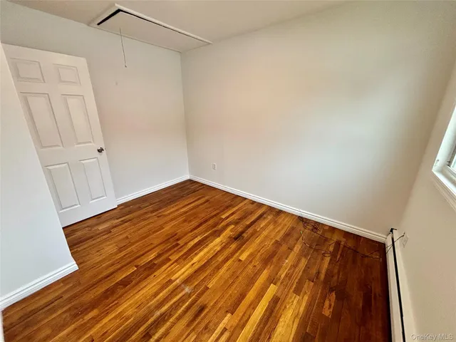a view of a room with wooden floor and white walls