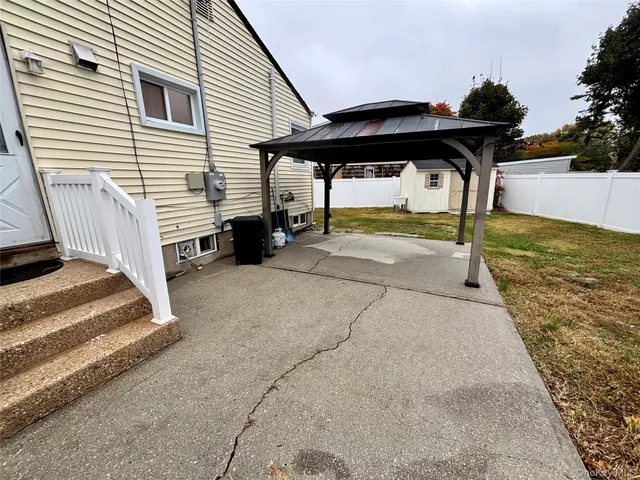 a view of a terrace with a table and chairs under an umbrella
