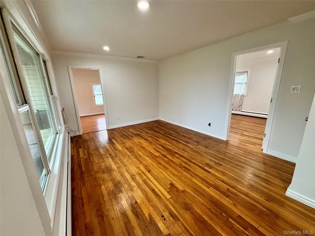 a view of empty room with wooden floor