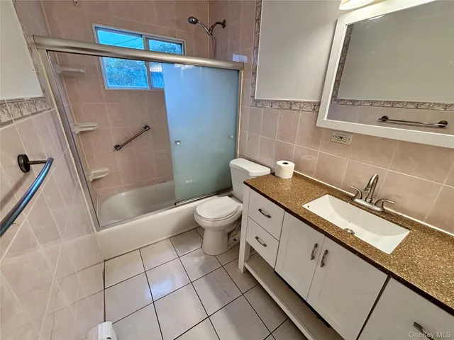 a bathroom with a granite countertop sink a toilet and a bathtub