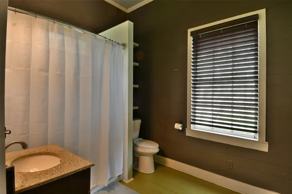 a bathroom with a granite countertop sink toilet and mirror