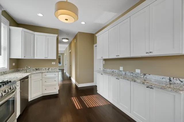 a kitchen with granite countertop a white cabinets and sink