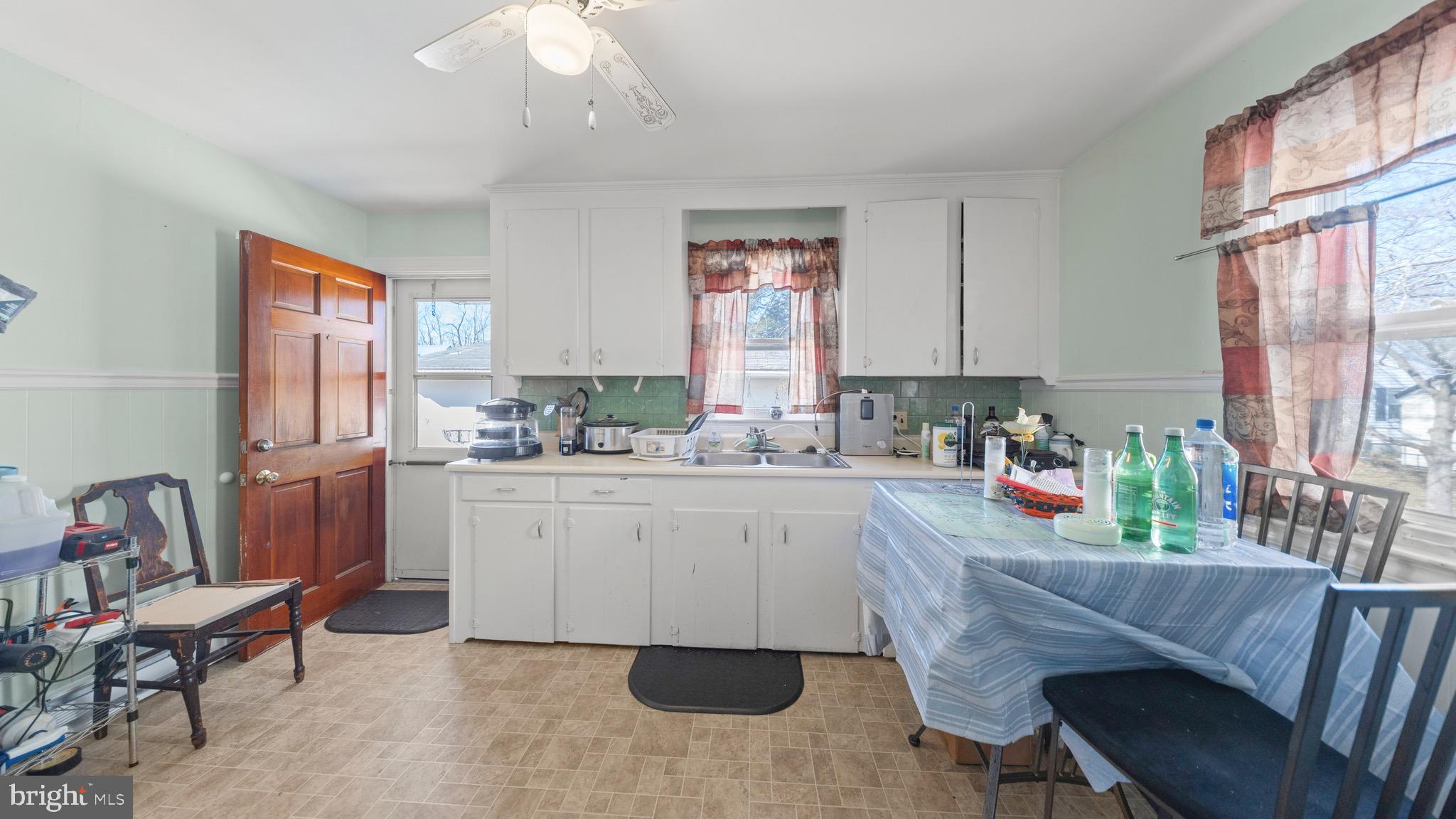 704 Madison Street Salisbury, MD 21804 - Photo 4 of 17 a kitchen with a dining table chairs sink and cabinets