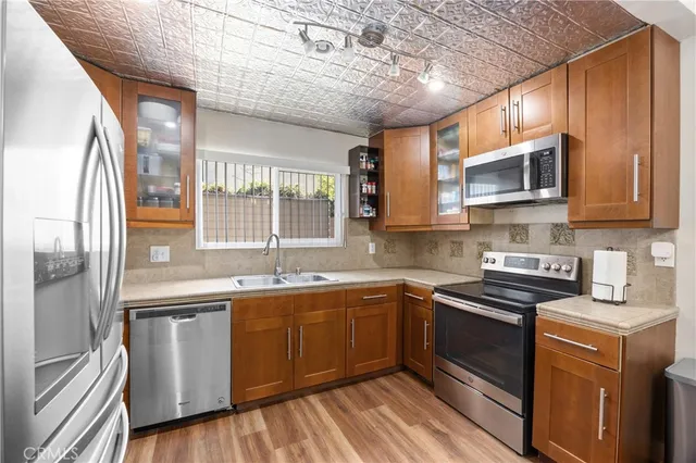 a kitchen with stainless steel appliances granite countertop wooden cabinets a sink and a stove