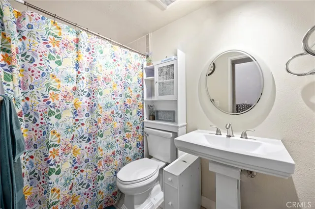 a bathroom with a sink toilet and a mirror
