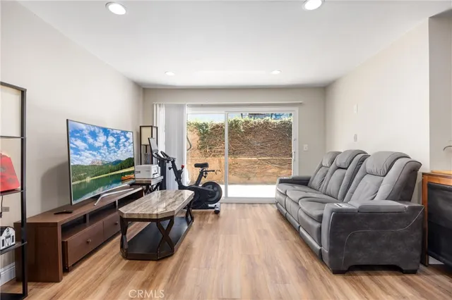 a living room with furniture flat screen tv and wooden floor