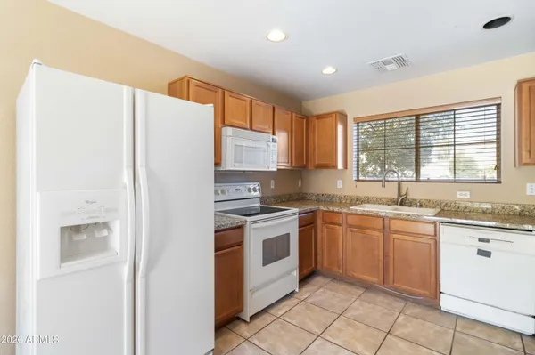 a kitchen with granite countertop stainless steel appliances a sink and cabinets