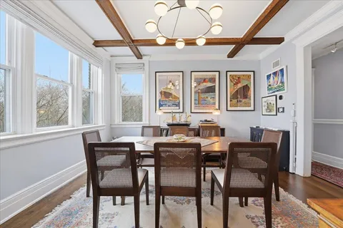 a view of a dining room with furniture a chandelier and wooden floor