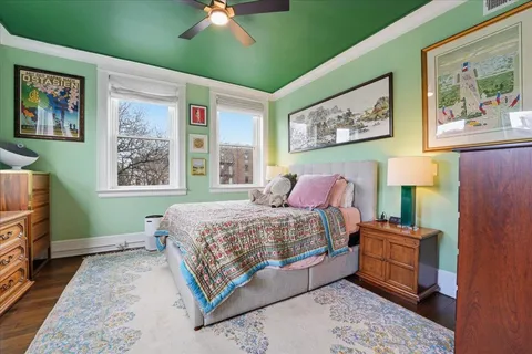 a bedroom with a bed and a painting on the wall