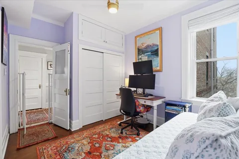 a view of a bedroom with workspace and a window