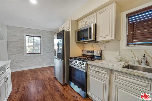 a kitchen with stainless steel appliances a refrigerator and a stove top oven