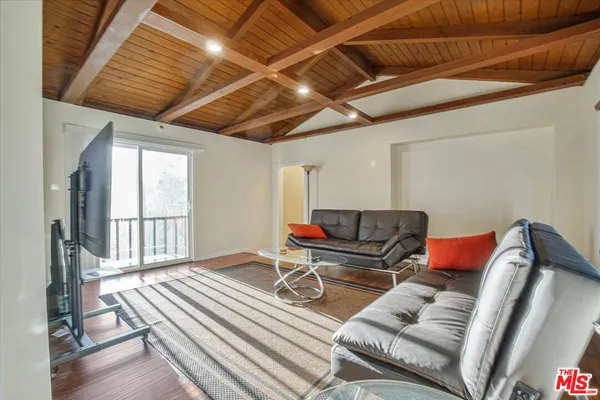 a bedroom with a bed and a dresser next to a window