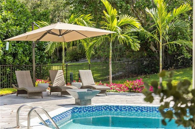 a view of a sitting area with swimming pool and furniture