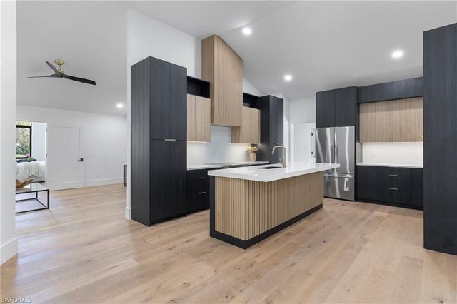 a large kitchen with a refrigerator and a sink