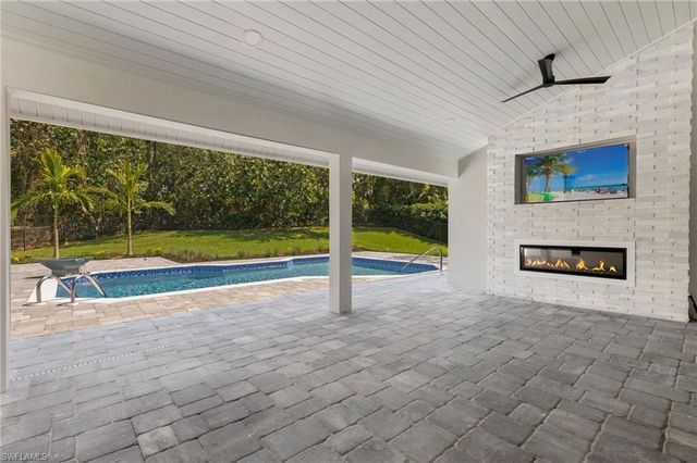 a view of an empty room with a floor to ceiling window and pool table