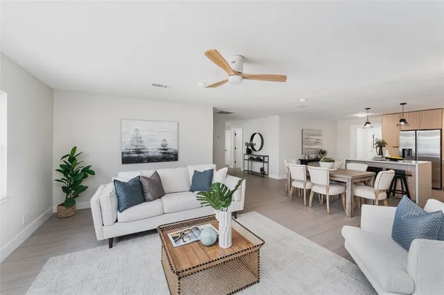 a living room with furniture kitchen and a chandelier