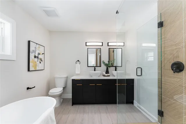 a bathroom with a double vanity sink toilet and mirror