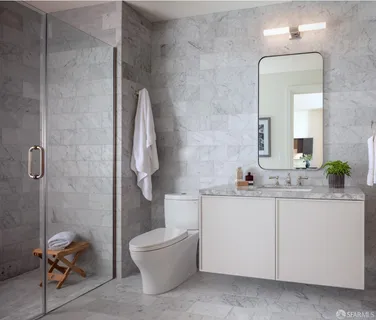 a bathroom with a granite countertop sink a toilet and a mirror