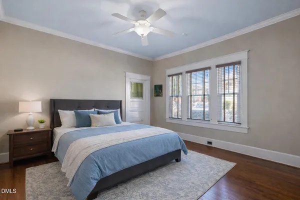 a bedroom with a large bed and a chandelier