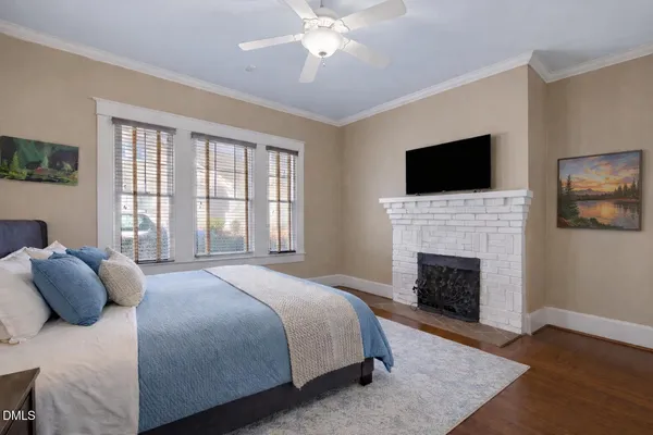 a bedroom with a large bed and a fireplace