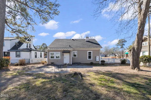 a view of a house with a big yard and large tree
