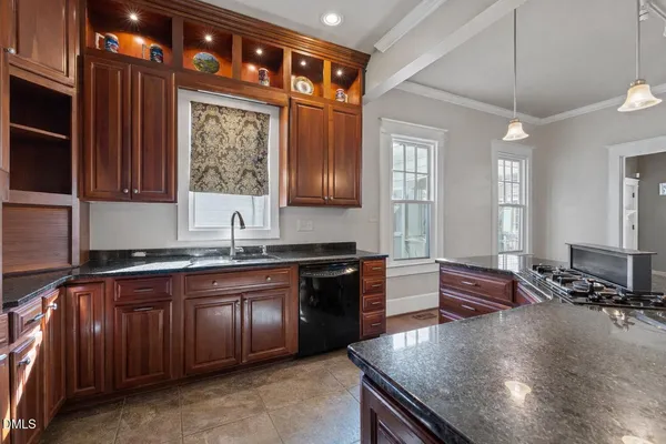 a large kitchen with granite countertop a stove sink and cabinets