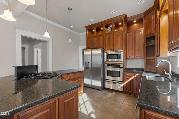a kitchen with stainless steel appliances granite countertop a sink and a refrigerator
