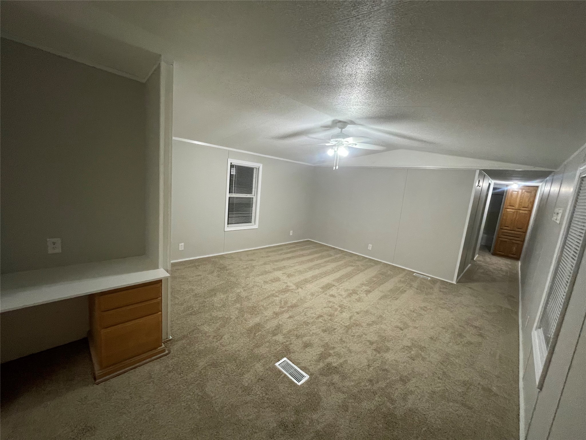 215 Greenfield Road Kyle, TX 78640 - Photo 8 of 8 A spacious primary bedroom features soft carpeting and a ceiling fan, offering a comfortable retreat.