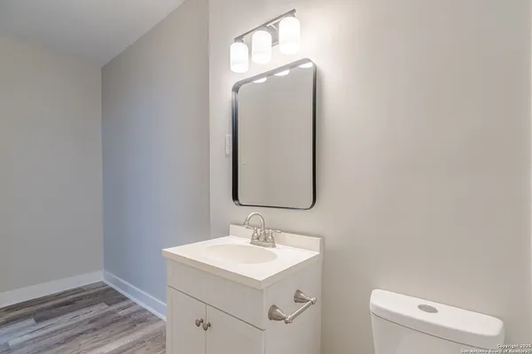 a bathroom with a sink vanity and a toilet
