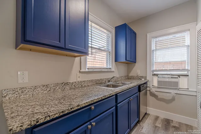 a kitchen with granite countertop cabinets sink and window