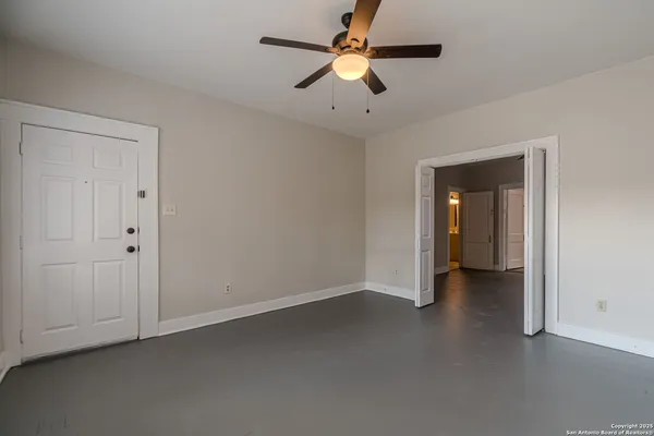 an empty room with closet and a ceiling fan